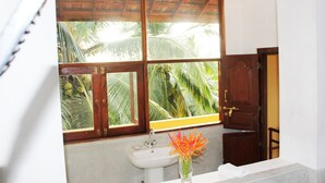 A bathroom with a large window, a sink, and a wooden door. - Peacock Point - Whole Villa 2 Bedroom (Sleeps 4) (Ahangama)