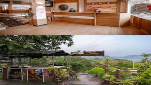Zona de recepción de un hotel con muebles de madera y un amplio ventanal con vistas panorámicas.