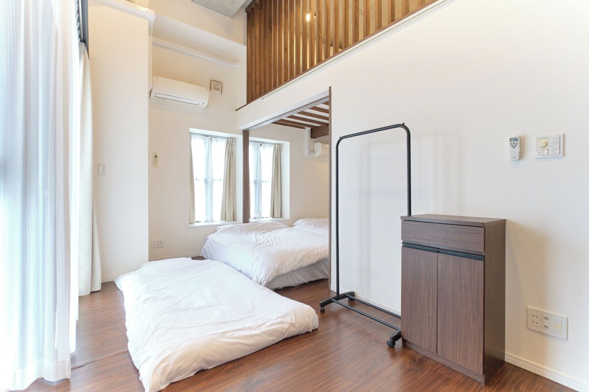 Een hotelkamer met twee bedden, een bureau en een kledingkast.