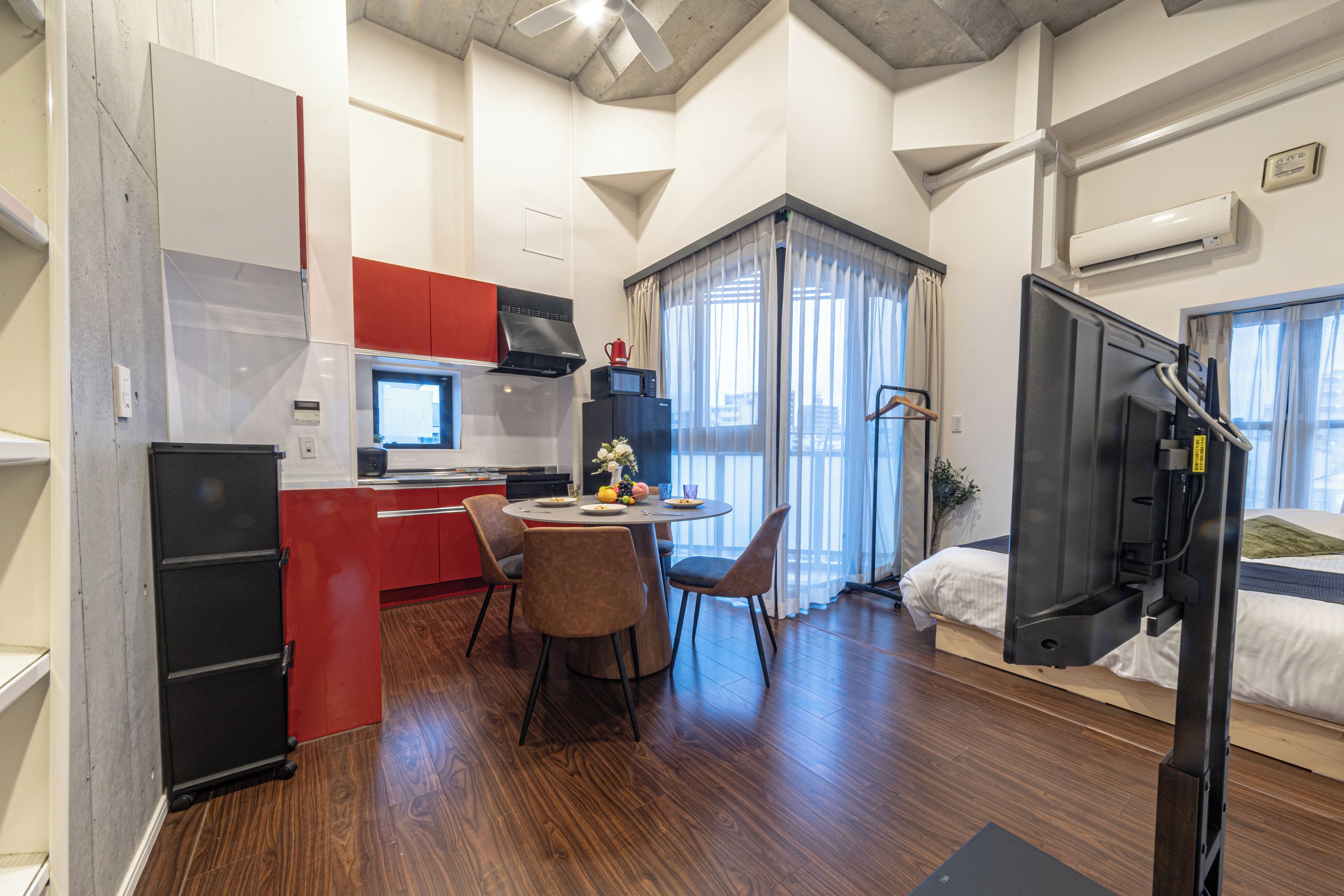 A compact living space with a kitchenette, a dining area, and a bedroom.