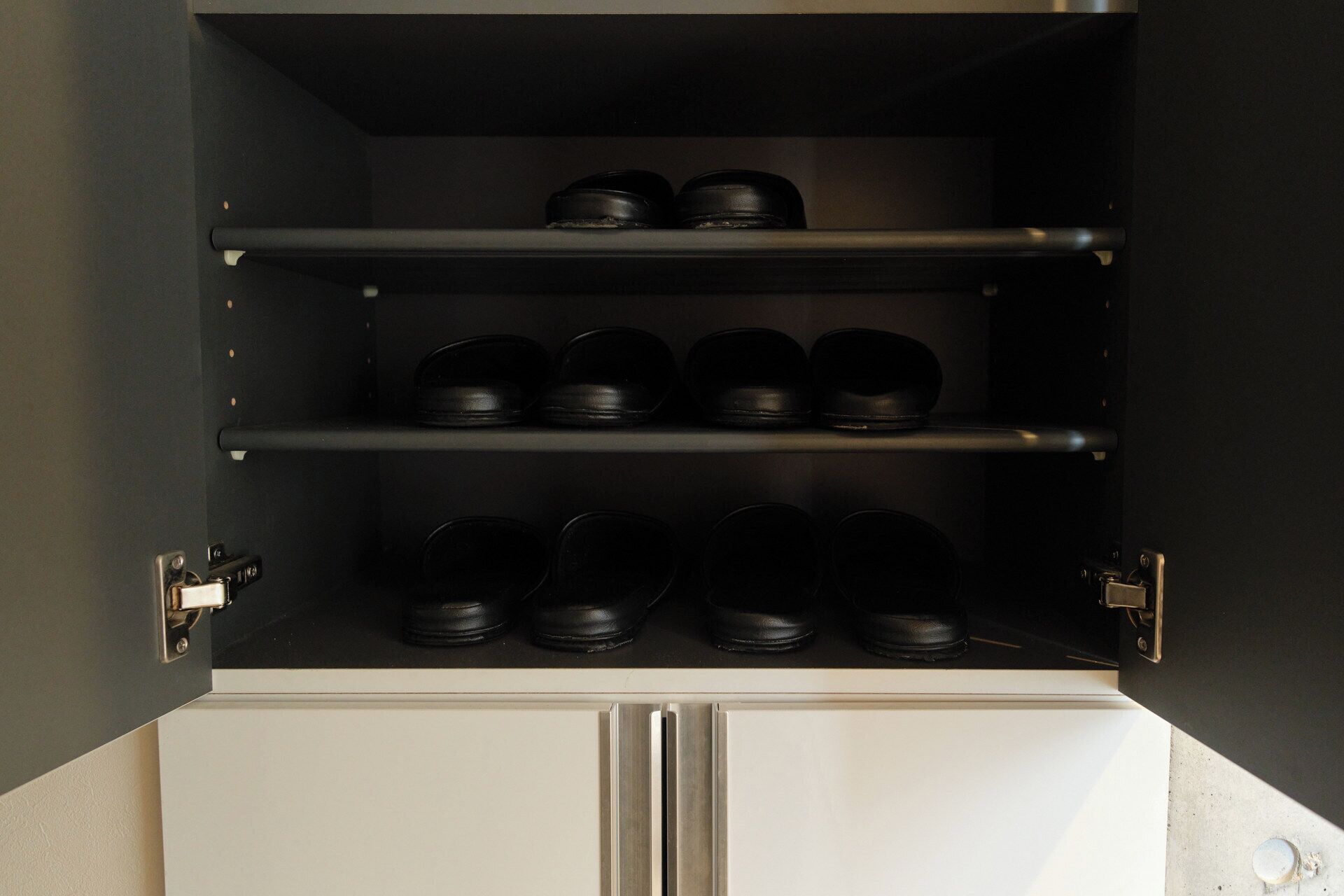 A storage unit with multiple shelves, each holding several black containers.