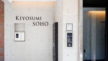 A wall with the text "KIYOSUMI SOHO" and two elevator control panels.