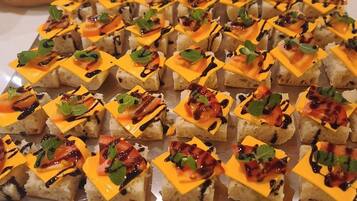 A table with square appetizers arranged in rows.