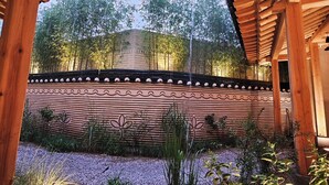 Una estructura de pérgola de madera con vista a un jardín y árboles.