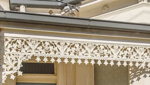 A building entrance with a decorative metal gate, a small window with a patterned blind, and a tiled floor. - Gorgeous 2-Bed Victorian Home in Artsy Suburb (Brunswick)