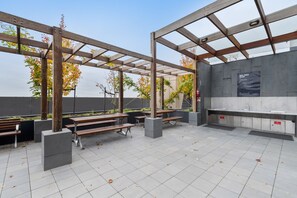 Relax in the shaded patio area with a barbecue station and comfortable seating.