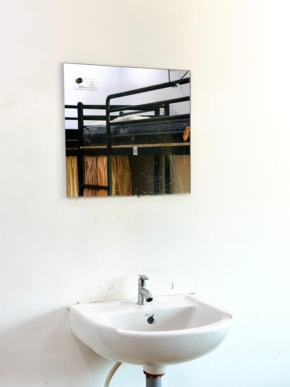 Une salle de bain avec un lavabo blanc et un miroir au-dessus.