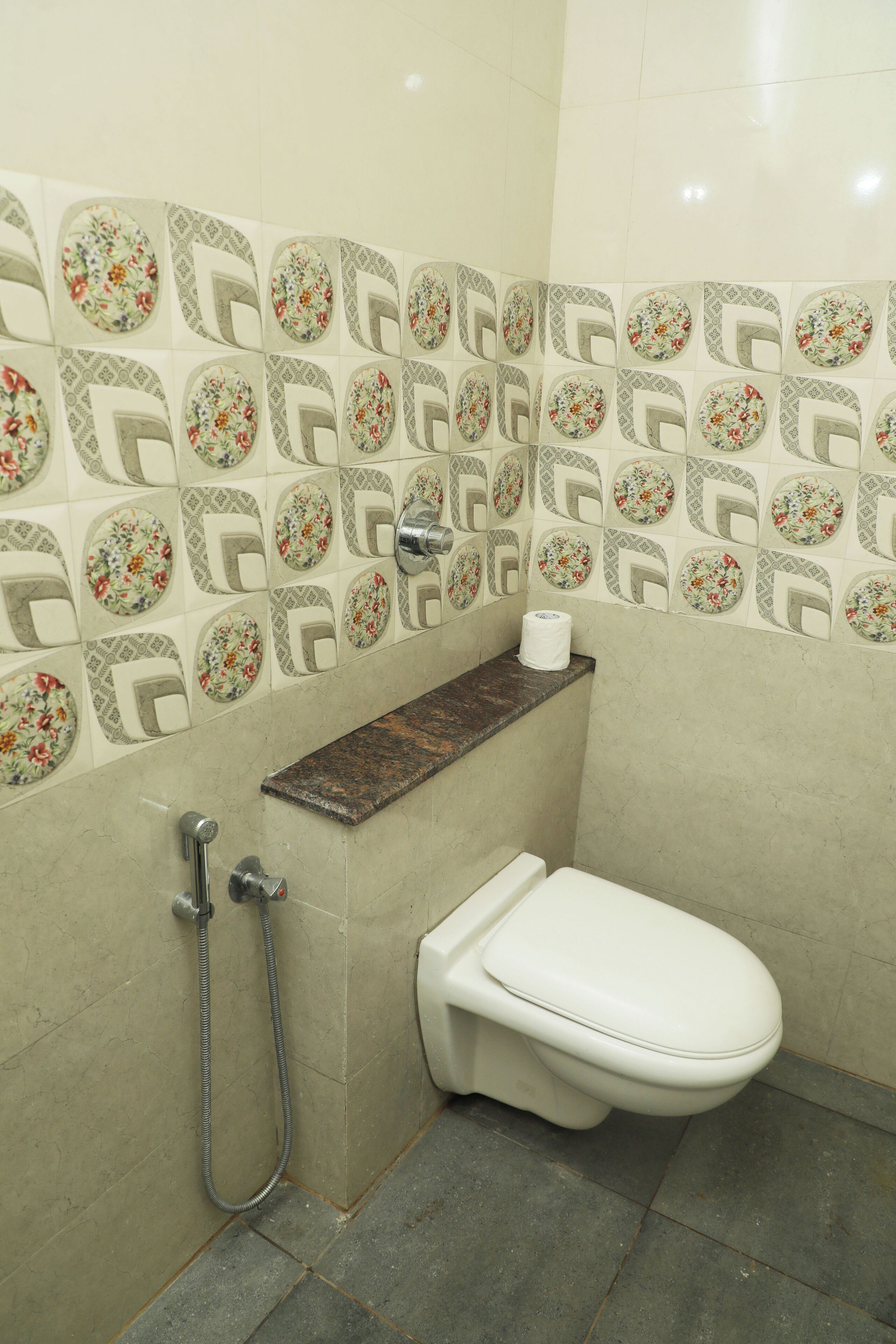 A bathroom with a toilet, a shower, and a towel rack.