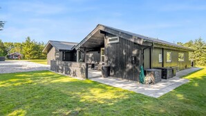 Een modern, tweelaags gebouw met een overdekte patio en een klein terras.