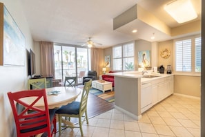 A compact hotel room with a dining area, kitchenette, and a balcony with a view. - Pelikana Lanai, Lazy River, Great Location! (Fort Walton Beach)