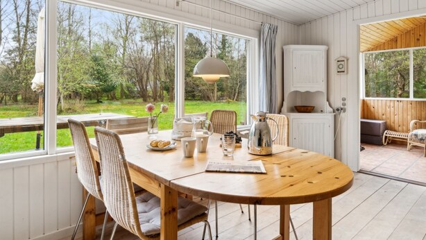 A wooden dining table with chairs, a coffee pot, and a view of a garden through large windows. - "Karl" - 4km from the sea by Interhome (Frederiksværk)