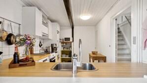 A modern kitchen with a wooden countertop, stainless steel sink, and white cabinetry. - "Santuzza" - 100m from the sea by Interhome (Svaneke)