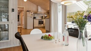 Une cuisine moderne avec des armoires blanches, un réfrigérateur en acier inoxydable et un four encastré.