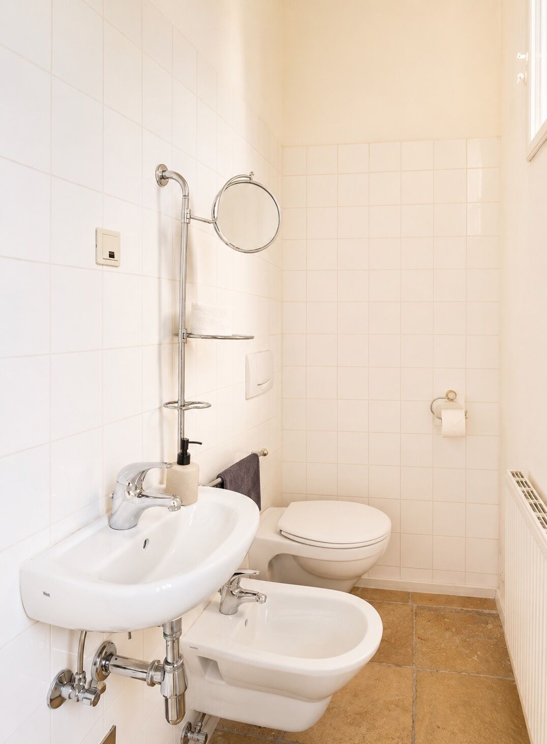 Ein Badezimmer mit Waschbecken, Bidet, Toilette und Handtuchhalter.