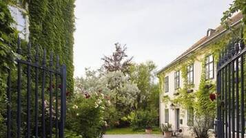 A courtyard with a gravel path, surrounded by buildings covered in ivy.