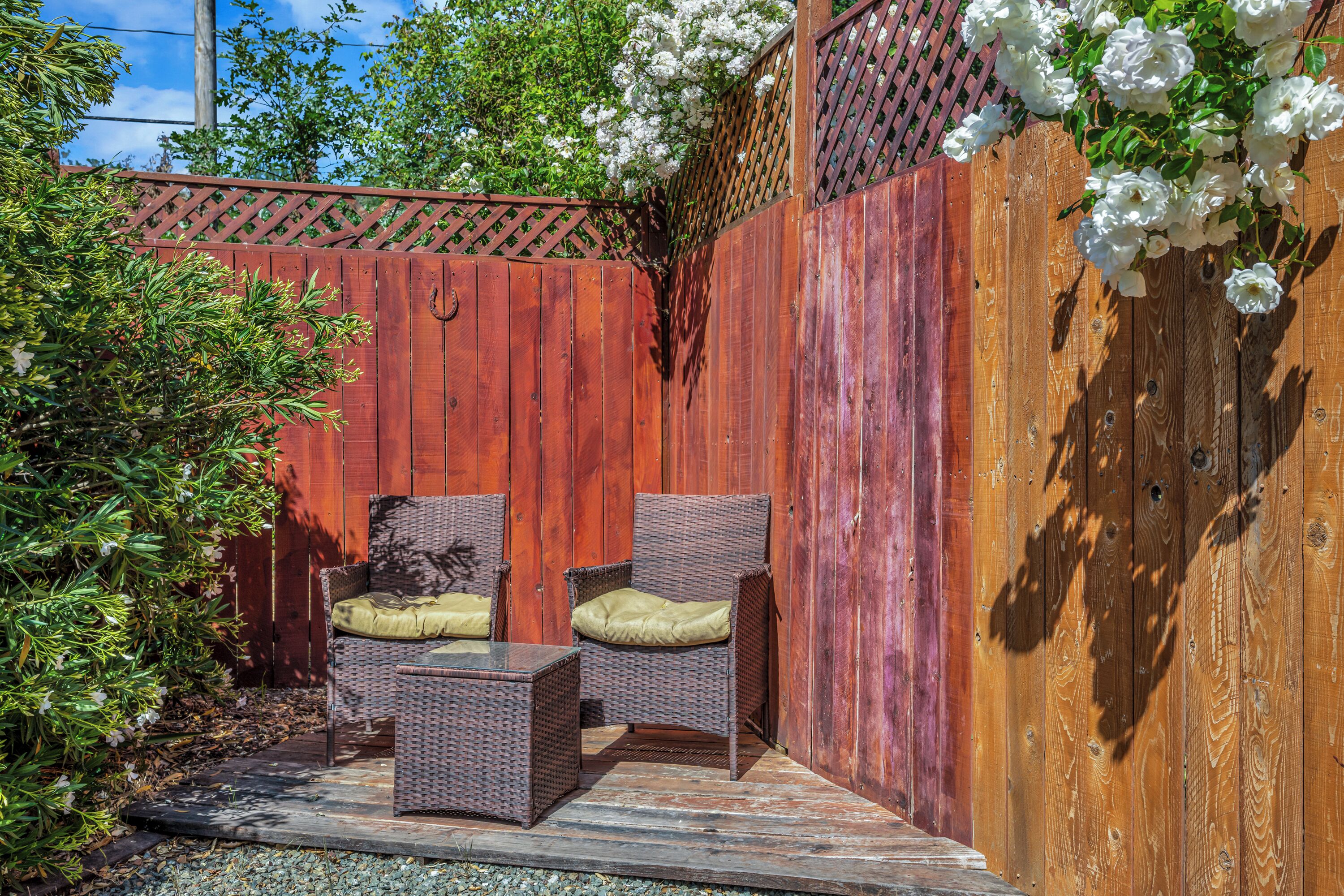 A wooden deck with wicker furniture and a lattice fence.