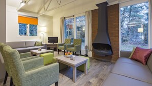 Un salon moderne avec un canapé, des fauteuils, une table basse et une cheminée.