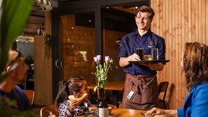 A waiter serving drinks to guests at a wooden table in a restaurant. - Relax & Unwind in Putten (Putten)