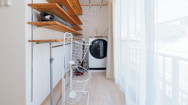 A laundry area with wooden shelves, a drying rack, and a washing machine. - Convertel Daita Setagaya Daita by Tranova (Tokyo)