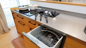 A kitchen with wooden cabinets, a stainless steel countertop, and a dishwasher. - Convertel Daita Setagaya Daita by Tranova (Tokyo)