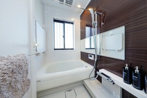 Bañera con ducha, secador de pelo, shampoo