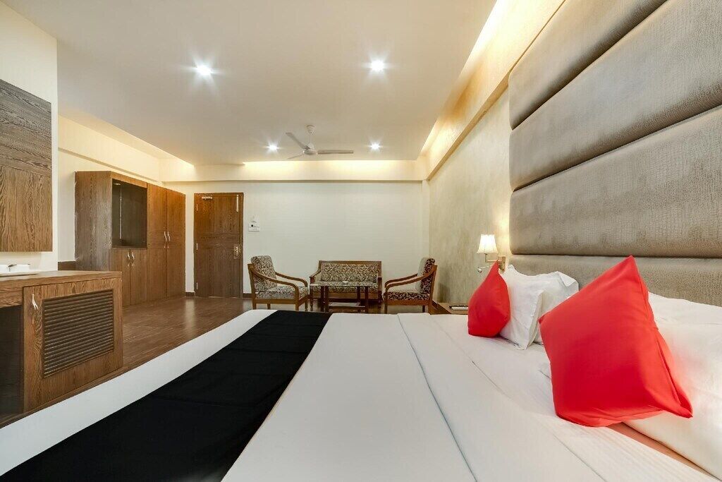 A hotel room with a bed, a desk, and two chairs.