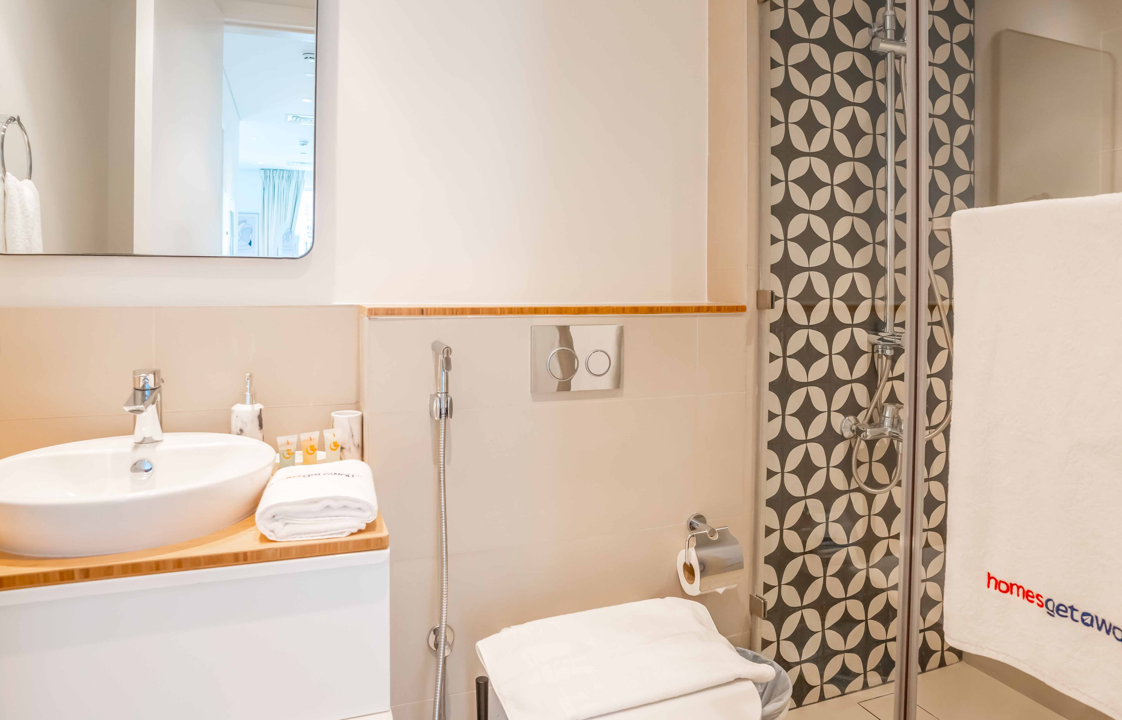 A bathroom with a large sink, toilet paper holder, and a shower area.