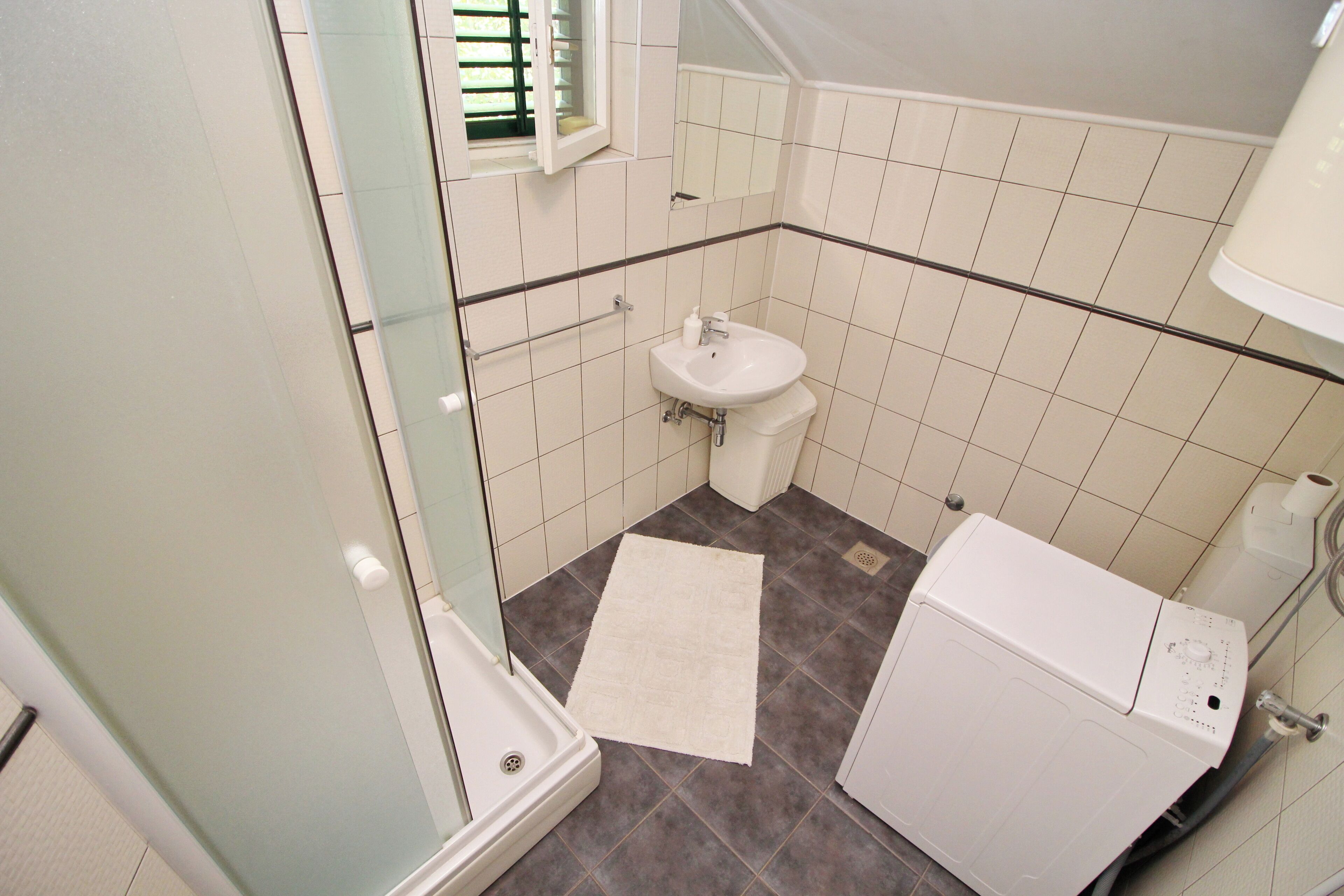 Une salle de bain avec une douche, un lavabo et des toilettes.