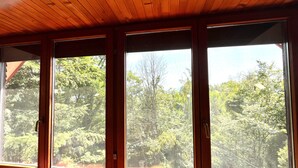 A room with large windows offering a view of dense trees. - Best of Ilidza Villa (Sarajevo)