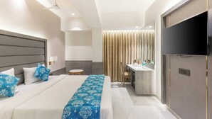 Une chambre d’hôtel moderne équipée d’un grand lit, d’un bureau, d’une télévision et d’une salle de bain.