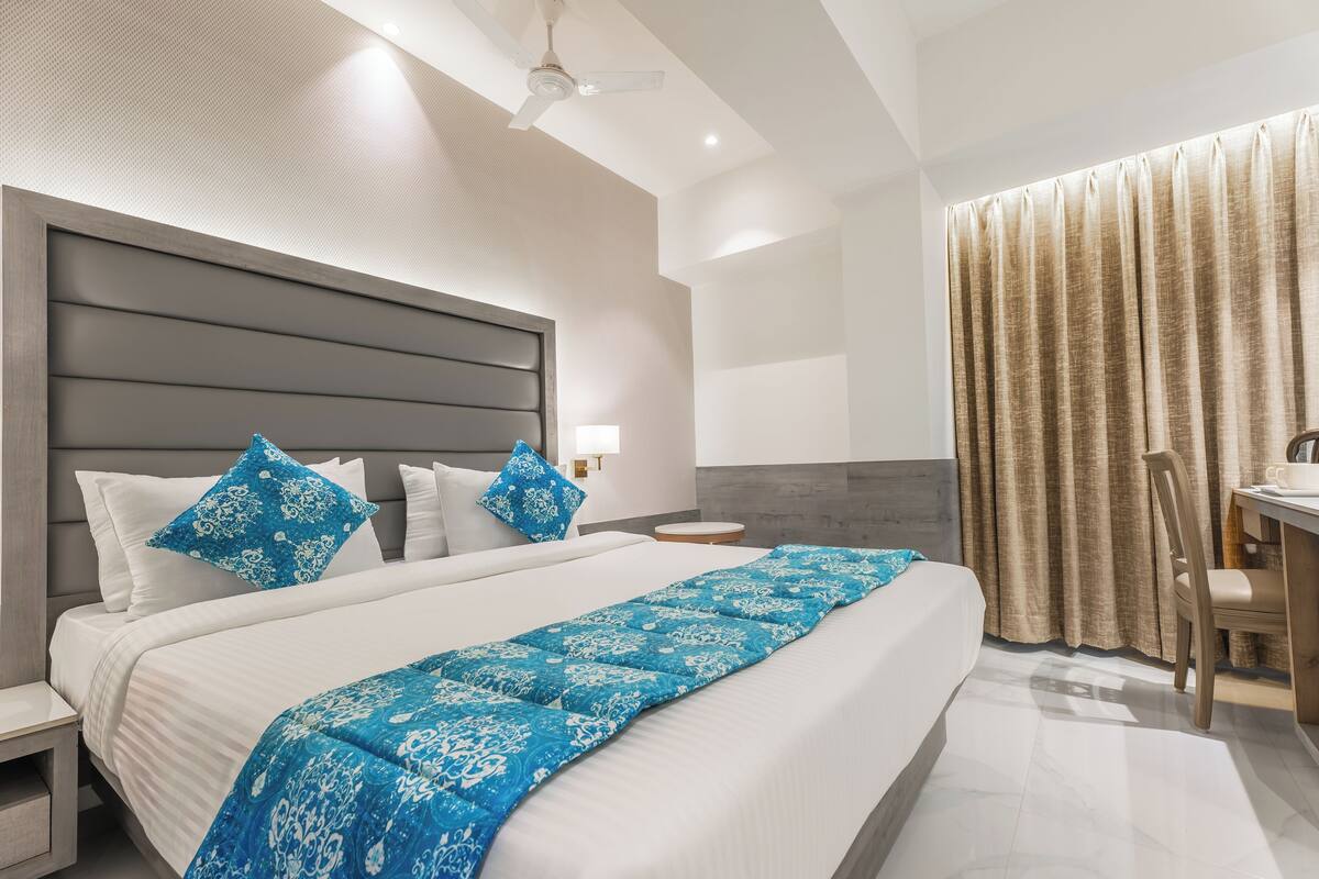 Una habitación de hotel con una cama grande, un escritorio y una silla.