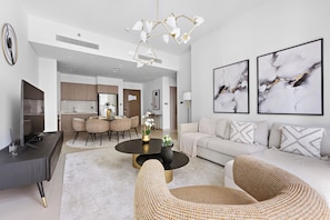 Relax in a stylish living area with a round dining table, comfortable sofa, and abstract art.