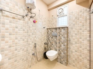 A bathroom with a shower, toilet, and a window. - Travelling Troopers Homestay (Varanasi)