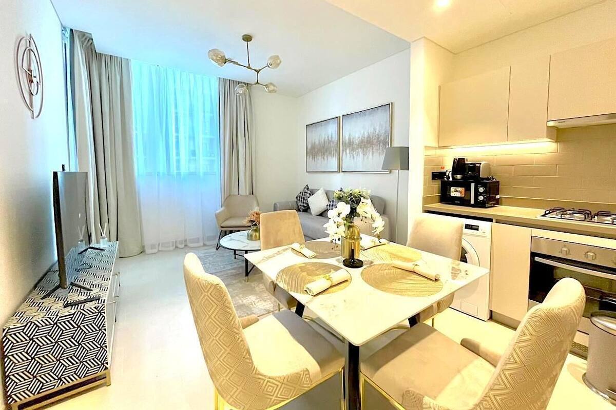 A modern living room with a dining area, a kitchen, and a sofa set.