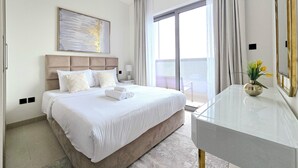 Een moderne hotelkamer met een groot bed, nachtkastje, bureau en balkon met uitzicht.