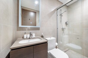 A modern bathroom with a sink, toilet, and glass-enclosed shower. - Sobha Creek Vista Tower A Apartments (Dubai)
