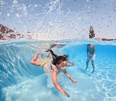 Una piscina al aire libre de temporada, sombrillas