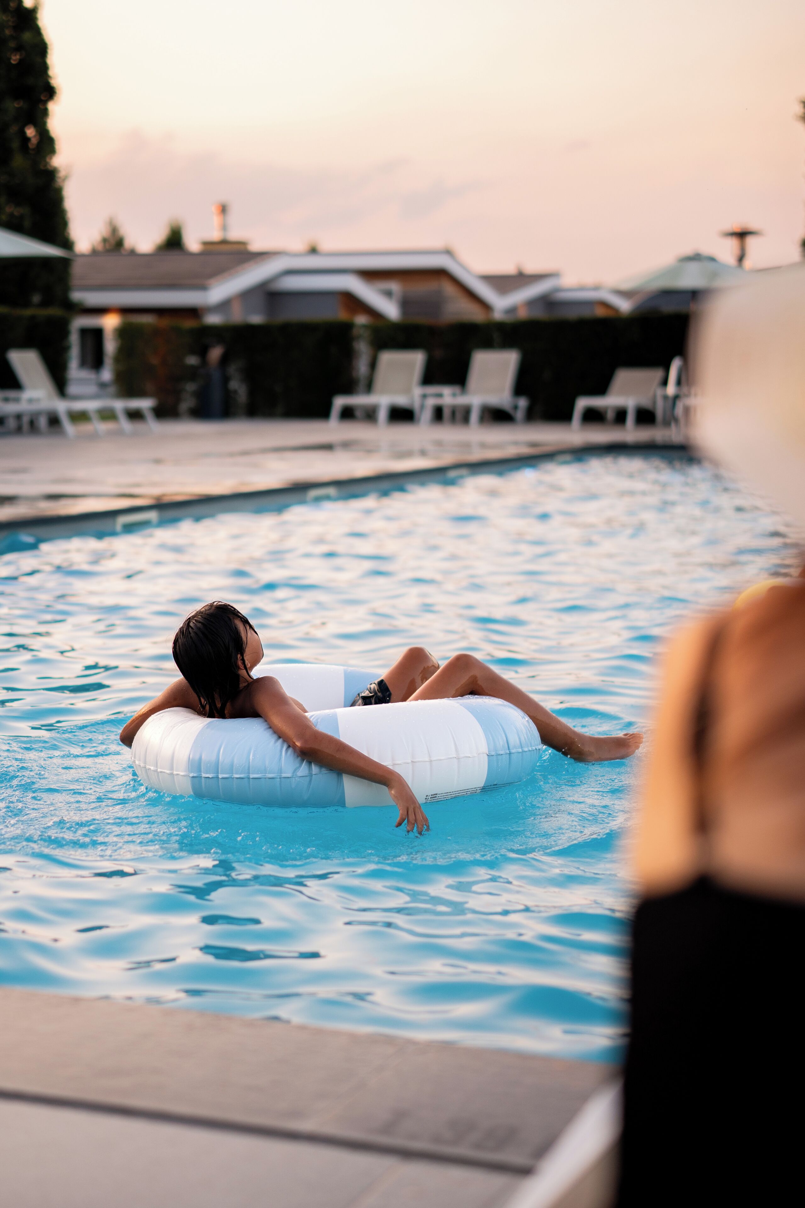 A person floating on an inflatable ring in a swimming pool.