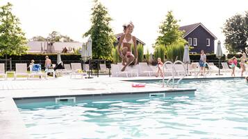 Una piscina al aire libre de temporada, sombrillas