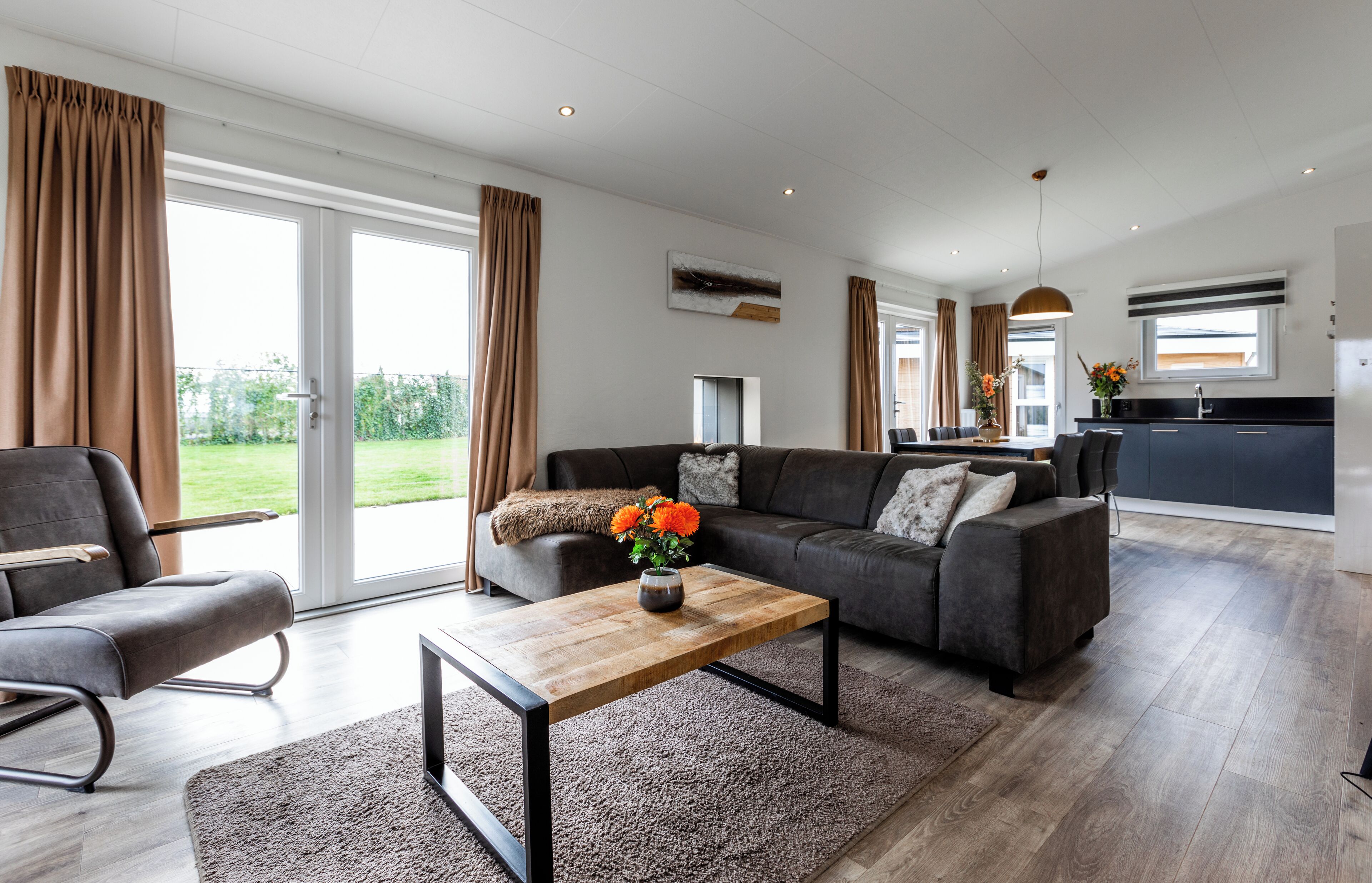 Un salon moderne avec un canapé, une table basse et une vue sur l’extérieur.
