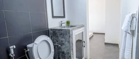 A modern bathroom with a toilet, sink, and shower.