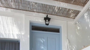 Una mesa de madera con un farol azul frente a una puerta blanca.
