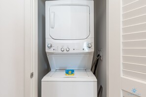 A compact washer and dryer unit with a control panel, a detergent box, and a hose. - Rooftop Pool –Oceanview Balcony| Beachfront Resort (Hollywood)