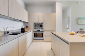 A modern kitchen with a built-in oven, microwave, and a large island with a toaster. - Rooftop Pool –Oceanview Balcony| Beachfront Resort (Hollywood)