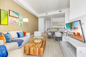 A modern living room with a sofa, coffee table, and artwork on the wall. - Rooftop Pool –Oceanview Balcony| Beachfront Resort (Hollywood)