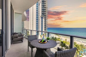 Ein Balkon mit Blick auf das Meer und einen Sonnenuntergang.