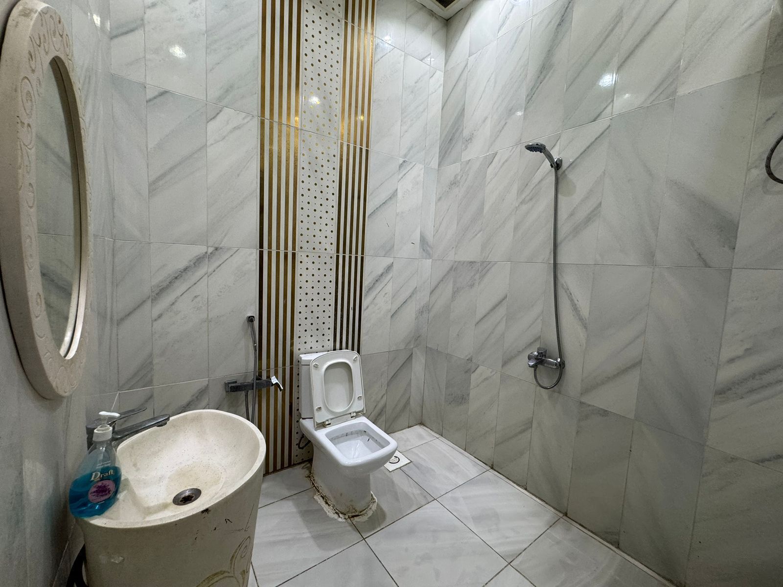 A bathroom with a toilet, sink, and shower.