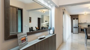A modern kitchen with a large mirror, a framed picture, and a vase on the counter. - Enjoy Summer from a lux flat steps to Sandy Beach (Maleme)