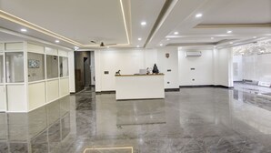 A spacious lobby with a reception desk, a glass partition, and a marble floor. - 360 Degree Hotel Medicity (Gurugram)