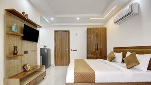 A modern bedroom with a wooden bed, built-in wardrobe, and a flat-screen TV. - 360 Degree Hotel Medicity (Gurugram)